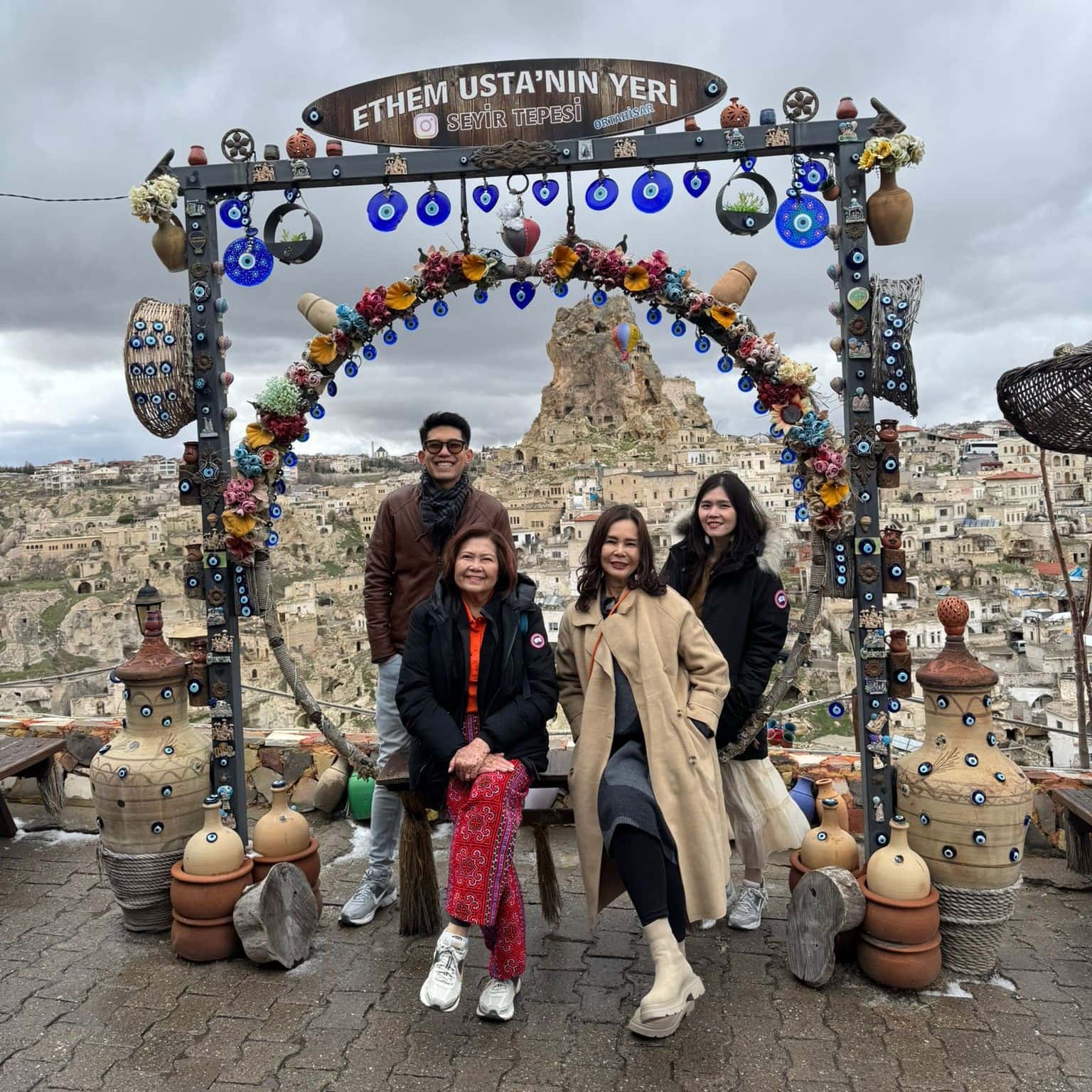 Group of 4-5 tourists at Ortahisar Panorama viewpoint during sunset with Cappadocia VIP transfer service and scenic valley background
